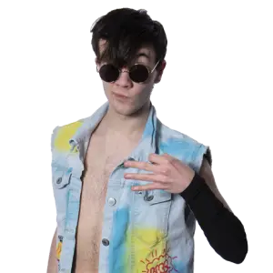 Riley stands on a multi coloured sleeveless denim jacket and a black sleeve on his left arm. wearing sunglasses.