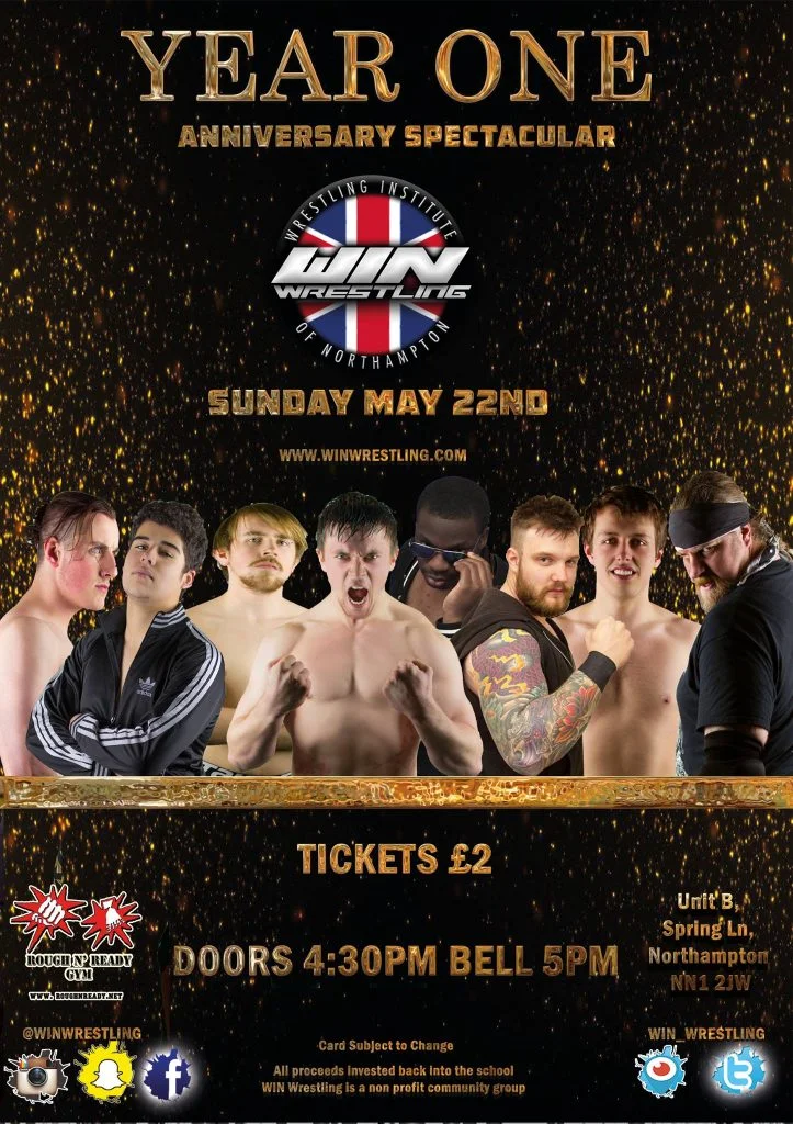 Year one in bronxe gold writing sits aboth the win logo and the date with a group of wrestlers from left to right. George James, Kid Max, Noah Blade, Ross Lee, Morgan Black, Man Known as Fowler, Dangerzone Adam Adams and Dean. Graves
