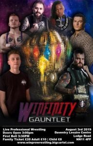 A group of wrestlers stand round what looks like Thanos' infinity gauntlet
