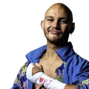 JJ wears a purple shellsuit jacket he points at wrist taple on his left hand which has a heart and pj written on it in red.