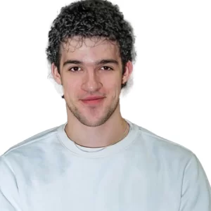 Jacob has dar curly hair and is wearing a white t-shirt