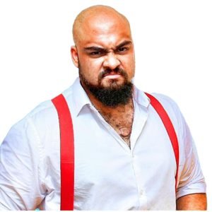 Kent Nelson is wearing a white dress shirt open collar with red suspenders