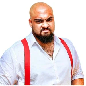 Kent Nelson is wearing a white dress shirt open collar with red suspenders