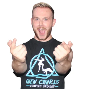 Owen stands pointing while wearing his shirt with a logo and the words Owen Charles Stomping Grounds