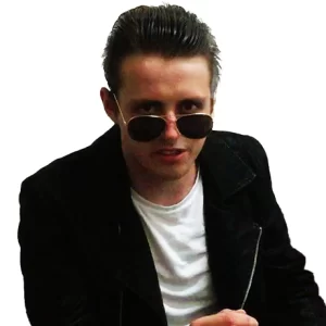 Adam Adams wears dark glasses and a white t-shirt and a white jacket.