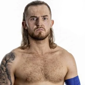 Adonis with long blond hair a tomato on his right arm and a blue sleeve on the other.