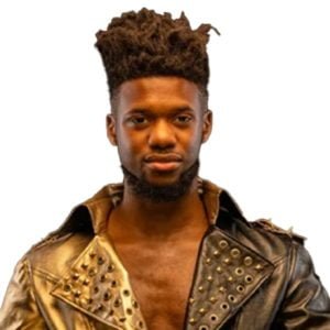 OJMO is wearing a studded leather jacket that is gold on one side black on the other