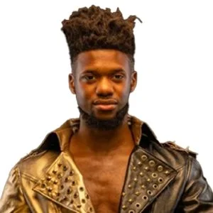 OJMO is wearing a studded leather jacket that is gold on one side black on the other