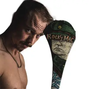 a man with short blonde hair and facial hair wearing a gold chain and his Irish hockey stick.