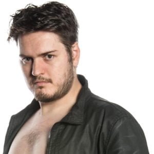 Toal stands looking at camera wearing a leather jacket