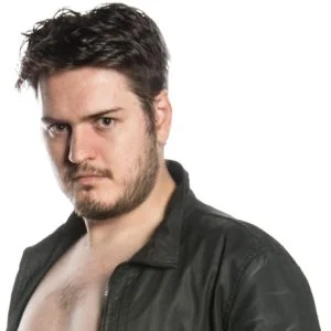 Toal stands looking at camera wearing a leather jacket