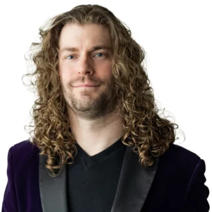 Dan is wearing a black t-shirt and purple velvet jacket