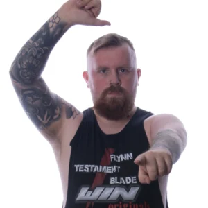 Noah stands one arm raised the other pointing at the camera wearing his win originals shirt